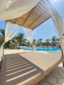 Cama con dosel en una playa con palmeras en Tay Beach Hotel Tayrona en Buritaca
