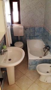 a bathroom with a sink and a tub and a toilet at Casa Maria Russo in Casal Velino