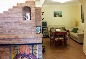 a living room with a brick fireplace and a table at Casa Maria Russo in Casal Velino +9 photos