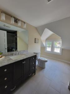 uma casa de banho com um lavatório, um WC e um espelho. em The Hidden Inn em South Kortright