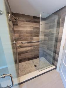 um chuveiro com uma porta de vidro na casa de banho em The Hidden Inn em South Kortright
