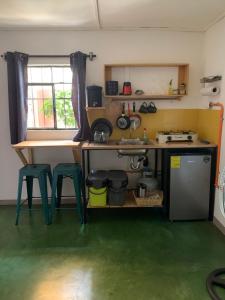 a kitchen with a counter and two stools in a room at Chirris Hostel in San Juan La Laguna