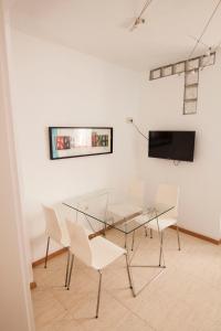 a dining room with a glass table and white chairs at Cozy house near to the city center of Granada in Granada