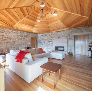 uma sala de estar com um sofá branco e uma parede de pedra em Casa da Moiroa em Sendim