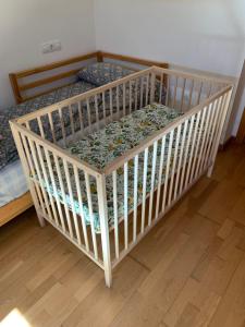 a small crib in a room with a wooden floor at Pilgrim’s House in O Pedrouzo