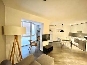 GORGEOUS APARTMENT IN DOWNTOWN في برشلونة: غرفة معيشة ومطبخ مع طاولة وكراسي