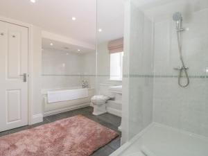 a bathroom with a tub and a toilet and a shower at Somerset House in Bridgwater