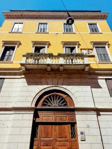 a yellow building with a wooden door and a balcony at Elle Palace Simply Elegant in Verona