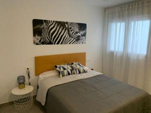 ein Schlafzimmer mit einem Bett mit zwei Zebras an der Wand in der Unterkunft APARTAMENTO ENCANTO II in Conil de la Frontera