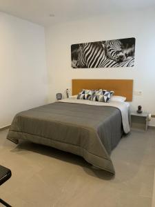 ein Schlafzimmer mit einem großen Bett mit zwei Zebras drauf in der Unterkunft APARTAMENTO ENCANTO II in Conil de la Frontera