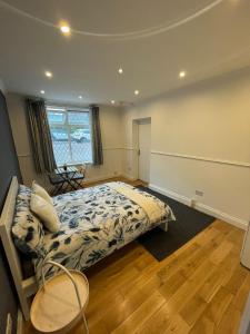 a bedroom with a bed and a chair in it at Wembley Rooms in London