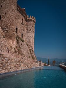 ein Schloss mit einem Wasserpool neben einer Mauer in der Unterkunft Castello di Rocca Cilento in Rocca Cilento