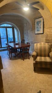 a dining room with a table and a couch at Birbuba House 2 in Għarb