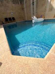 a swimming pool with a toy elephant in the middle at Birbuba House 2 in Għarb