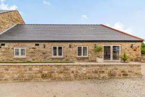 a stone house with a stone wall in front of it at The Dairy in Chesterfield