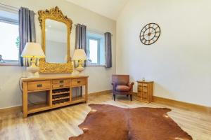 a room with a mirror and a dresser and a chair at The Dairy in Chesterfield