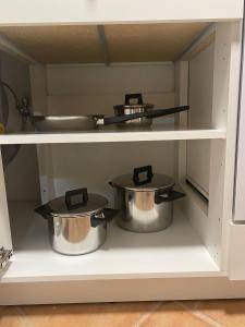 two pots and pans on a shelf in a kitchen at Apulian Way in Torre Pelosa