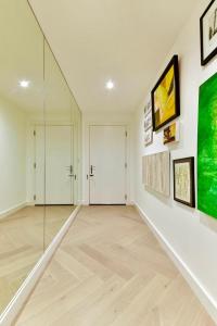 an empty room with a hallway with paintings on the wall at Chelsea Pad by condokeeper in London