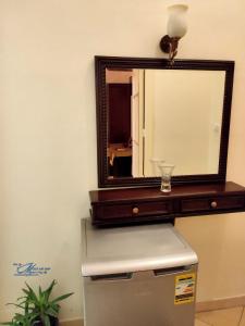 a mirror on top of a refrigerator in a room at Triomphe Hostel in Alexandria