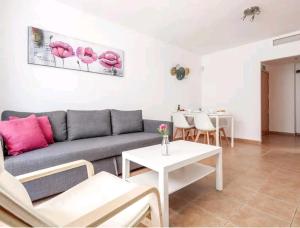 a living room with a couch and a table at Apartamento con patio y piscina cerca de Sevilla in La Algaba