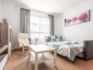 uma sala de estar com uma cama e um sofá em Apartamento con patio y piscina cerca de Sevilla em La Algaba