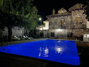 a blue pool in front of a building at night at Casa Rural La Moraleja in Villanueva del Arzobispo