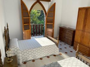 a bedroom with two beds and a balcony at Alojamiento Rural La Moraleja in Villanueva del Arzobispo