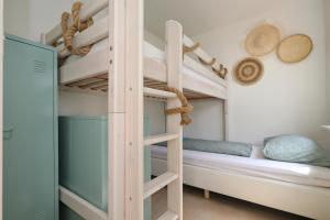a bunk bed in a bedroom with a bunk bed in a room at Sunnybeachhouse aan het bos, tussen zee en meer. in Noordwijkerhout