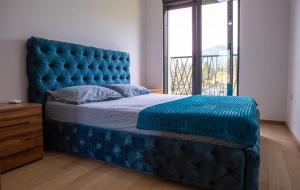 a blue bed in a bedroom with a large window at Apartment Lanterna in Tivat