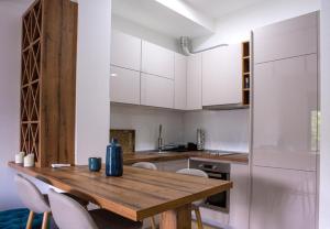 eine Küche mit einem Holztisch und weißen Schränken in der Unterkunft Apartment Ilija in Tivat