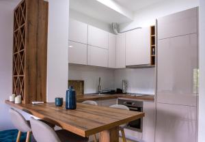 a kitchen with a wooden table and white cabinets at Apartment Lanterna in Tivat +4 photos