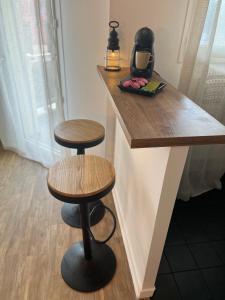 a counter with two stools sitting next to a table at Appartement Evry in Évry-les-Châteaux