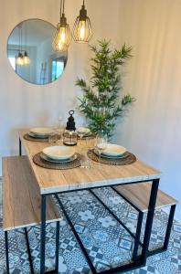 Appartement Evry في Évry-les-Châteaux: طاولة طعام مع نظارة وشجرة عيد الميلاد