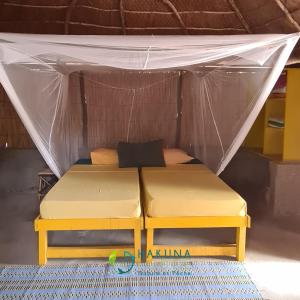 a bed in a tent in a room at Campement Hakuna Lodge in Mar Lodj