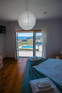 a bedroom with a bed and a view of a pool at Sorte do Castelo in Marco de Canavezes