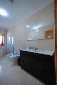 a bathroom with a sink and a tub and a toilet at Sorte do Castelo in Marco de Canavezes