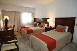 una habitación de hotel con dos camas y una silla en HR Esmeralda Luxor, en Buenos Aires 38 fotos más