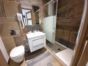 a bathroom with a toilet and a shower and a sink at Le Domaine de Wail Legends Resort in Wail