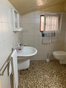 bagno con lavandino e servizi igienici di Casa di campagna Villa De Luca a Bellante