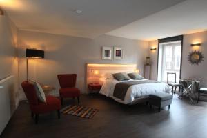 - une chambre avec un lit et une chaise rouge dans l'établissement LOGIS Hotel-Restaurant Le Relais d'Aligre, à Châteauneuf-en-Thymerais