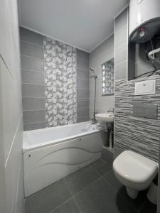 uma casa de banho com uma banheira, um WC e um lavatório. em NEW STAIL em Bălţi