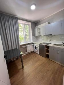 uma pequena cozinha com armários brancos e uma janela em NEW STAIL em Bălţi