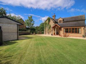 a large lawn in front of a house at Ellenhall Farm Cottage in Stafford