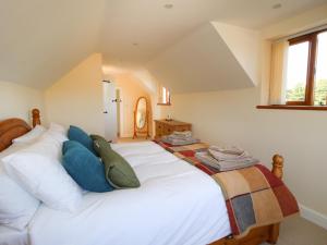 a bedroom with a large white bed with blue pillows at Ellenhall Farm Cottage in Stafford