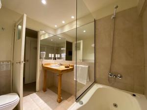 a bathroom with a tub and a sink and a toilet at Hosteria Kaiken in Tolhuin