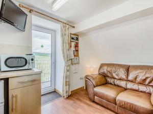 ein Wohnzimmer mit einem Sofa und einer Mikrowelle in der Unterkunft Glan Nug Bach in Betws-y-coed