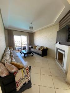 uma sala de estar com um sofá e uma lareira em Superbe appartement en résidence avec piscine em Casablanca
