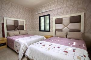 twee bedden naast elkaar in een slaapkamer bij Qamaras in Kaapstad