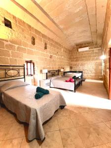una camera con due letti e un muro di mattoni di Birbuba House 2 a Għarb