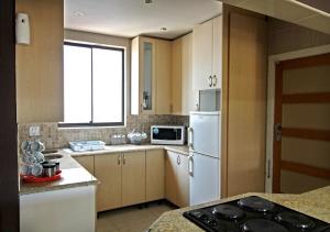 een keuken met een witte koelkast en een raam bij Qamaras in Kaapstad